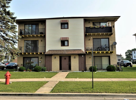 Front view of a three-story apartment building with balconies.