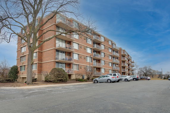 Front view of a multi-story apartment building with balconies.