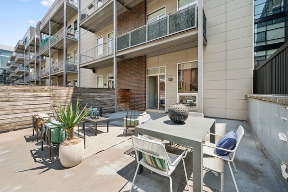 Outdoor view of a multi-story building with balconies and patio area.