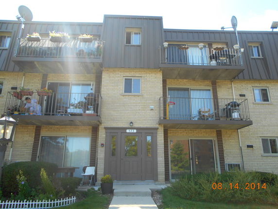 Front view of a multi-story apartment building with balconies.