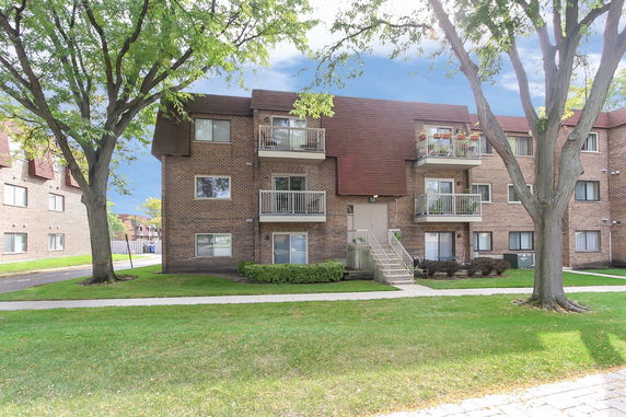 Front view of a three-story apartment building with balconies.