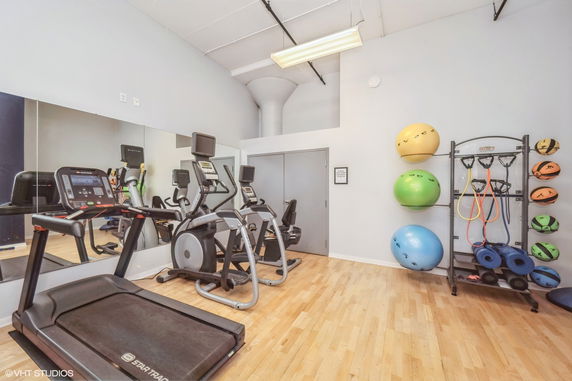 Interior view of a gym area with exercise equipment and fitness accessories.