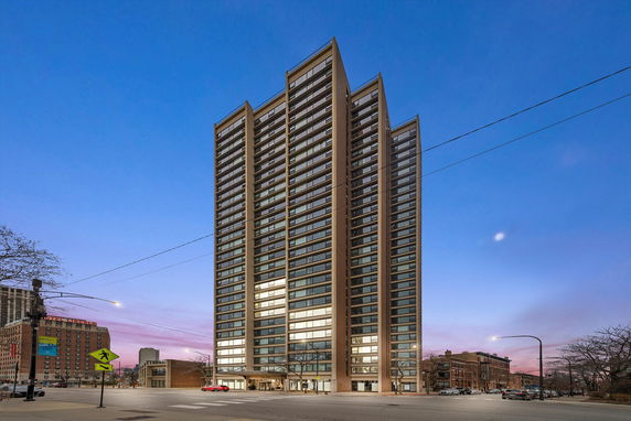 Front view of a tall, modern high-rise building with large windows.