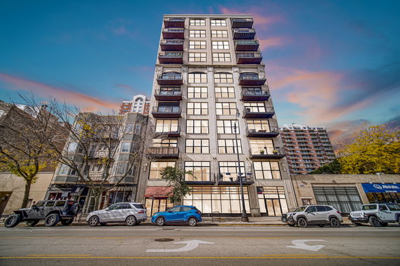 Front view of a multi-story apartment building with balconies.
