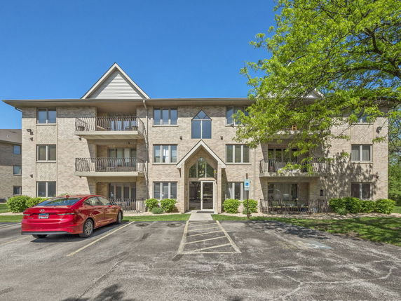 Front view of a three-story brick apartment building.