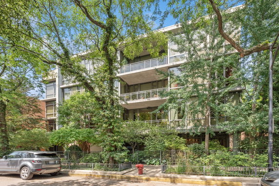 Front view of a multi-story condominium building with balconies and large windows.