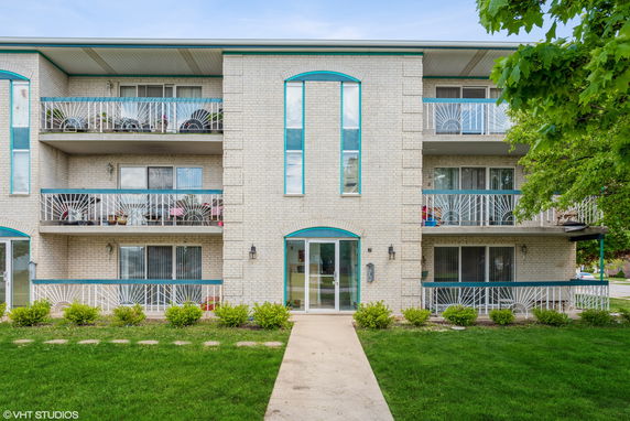 Front view of a three-story apartment building with balconies.