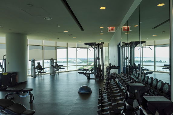 Indoor gym area with exercise equipment and large windows.