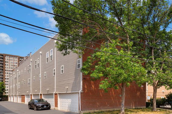 Side view of a multi-story residential building with multiple garages.
