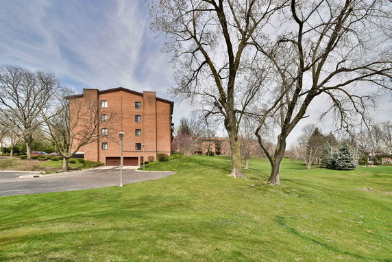 Side view of a multi-story brick building with a sloped roof.