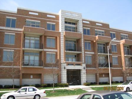 Front view of a multi-story brick apartment building with balconies.