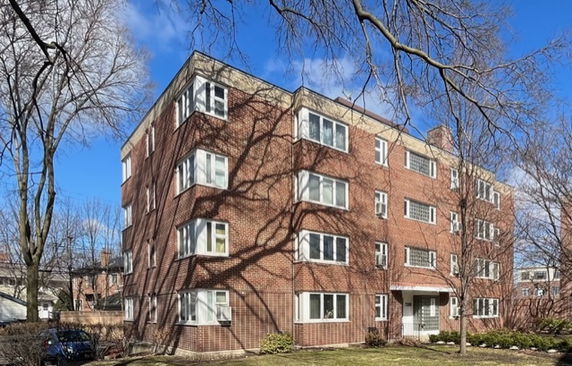Front view of a multi-story brick building with multiple windows.