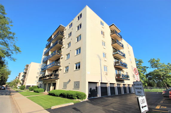 Front view of a multi-story apartment building with balconies.