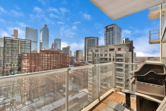 View from a balcony overlooking a city skyline with tall buildings.