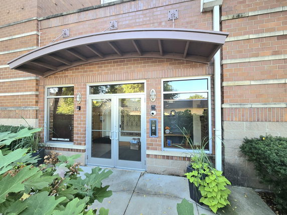 Front view of a brick building with glass double doors and windows.