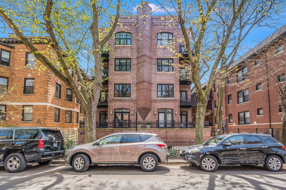 Front view of a multi-story brick building with balconies.