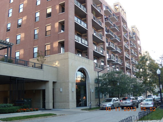 Front view of a multi-story apartment building with balconies.