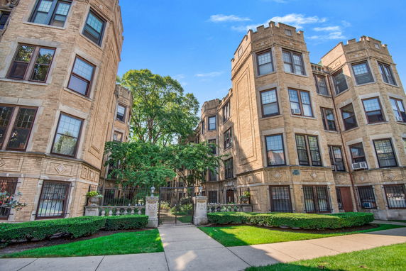 Front view of a multi-story brick apartment building with decorative elements.