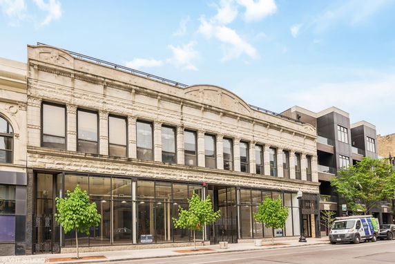 Front view of a two-story commercial building with large windows and ornate architectural details.