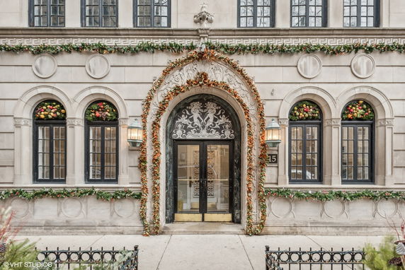 Front view of a decorated building with arched windows and a grand entrance.