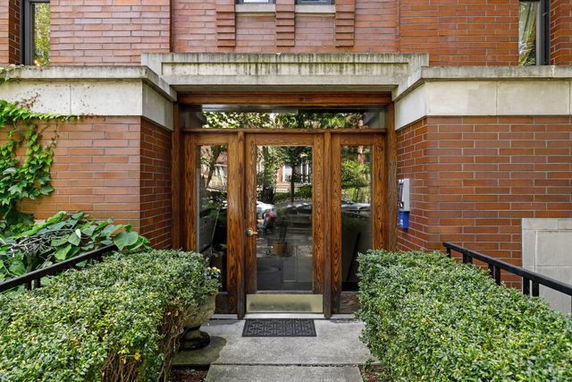 Front entrance of a brick building with wooden double doors.