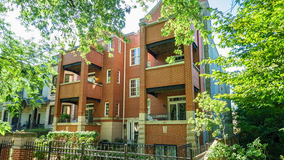 Front view of a multi-story brick building with balconies.