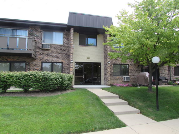 Front view of a two-story building with a brick facade and a covered entryway.