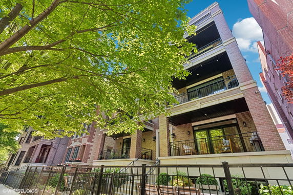 Front view of a multi-story brick apartment building with balconies.
