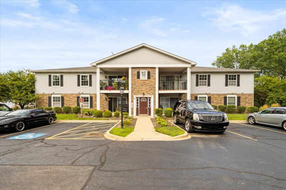 Front view of a two-story residential building with brick and siding exterior.