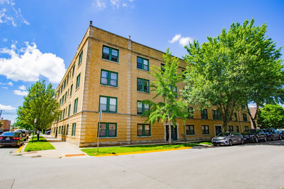 Front view of a four-story brick apartment building.