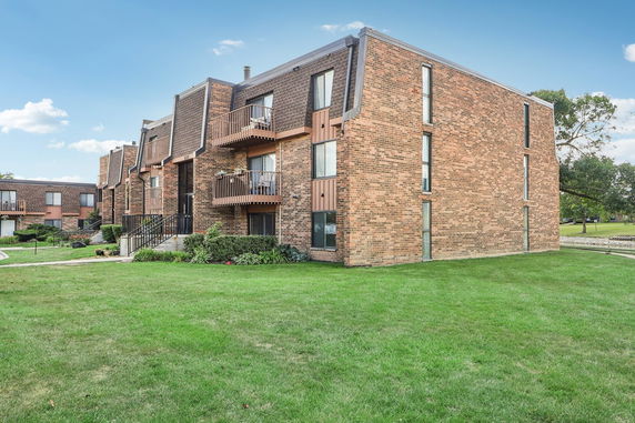Front view of a multi-story brick building with balconies.