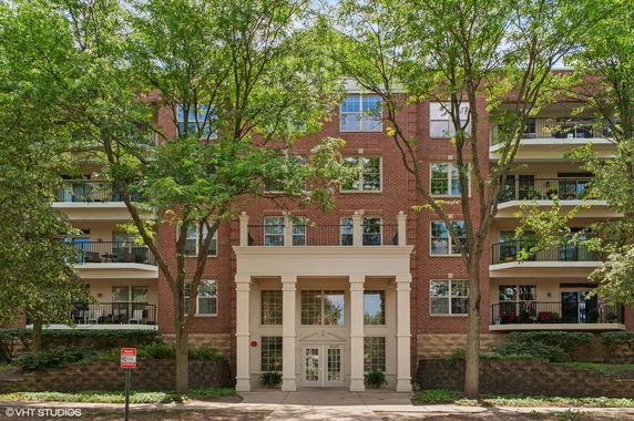 Front view of a multi-story brick apartment building with balconies.