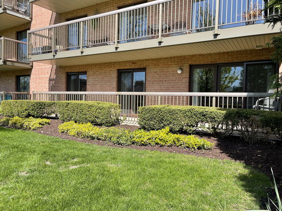 Front view of a multi-story building with balconies and a brick facade.