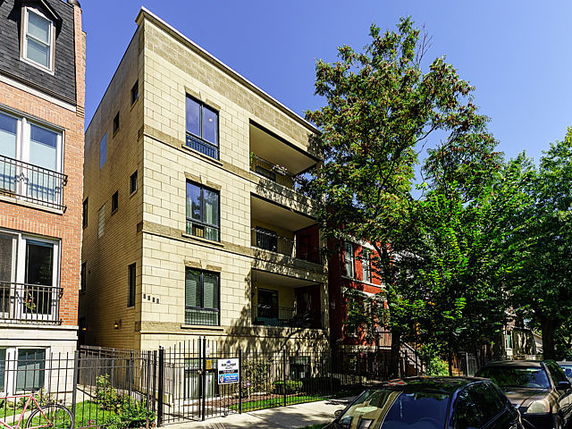 Front view of a multi-story apartment building with balconies.