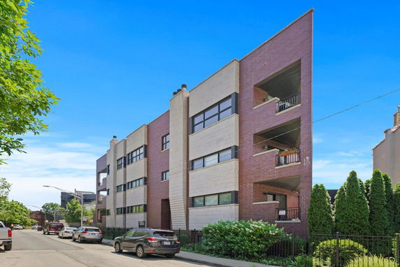 Front view of a modern multi-story building with brick and concrete facade.