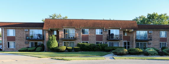 Front view of a two-story apartment building with balconies.