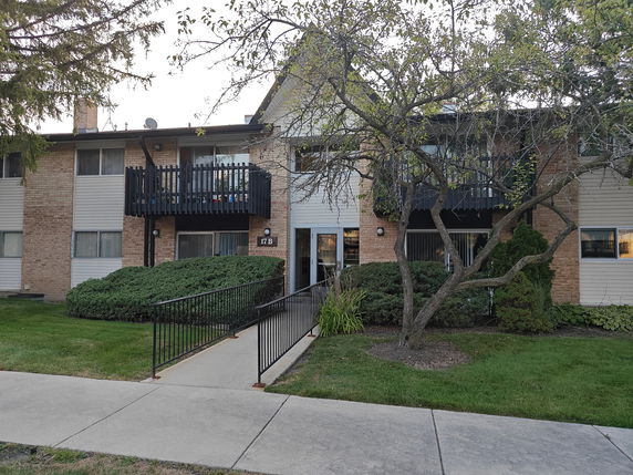 Front view of a two-story apartment building with balconies.