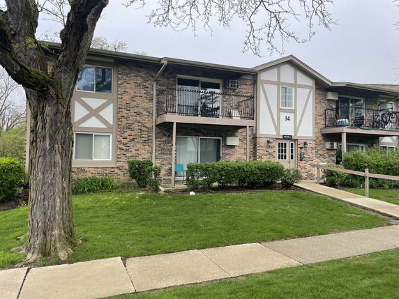 Front view of a two-story apartment building with balconies.