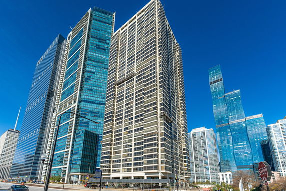 Front view of multiple modern high-rise buildings with glass facades in an urban setting.