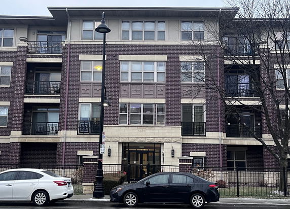 Front view of a multi-story residential building with brick facade.