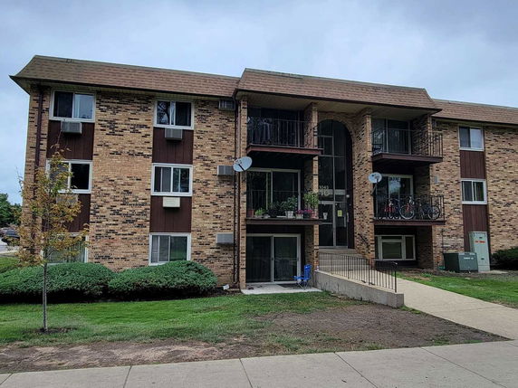 Front view of a multi-story apartment building with balconies.