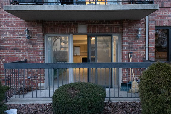 Front view of an apartment with a sliding glass door and brick exterior.
