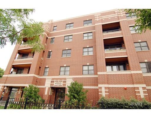 Front view of a multi-story brick apartment building with balconies.
