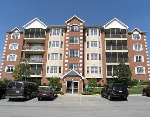 Front view of a multi-story residential building with brick facade and balconies.