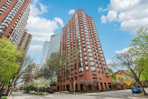 Front view of a tall, red-brick apartment building.