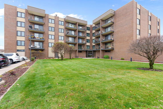 Front view of a multi-story apartment building with balconies.