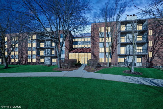 Front view of a multi-story building with balconies and large windows.