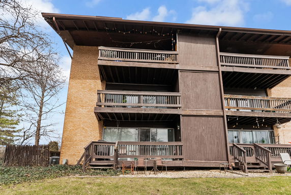 Front view of a multi-story building with balconies and brick facade.