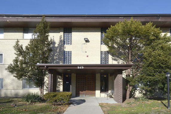 Front view of a three-story building with a covered entrance.