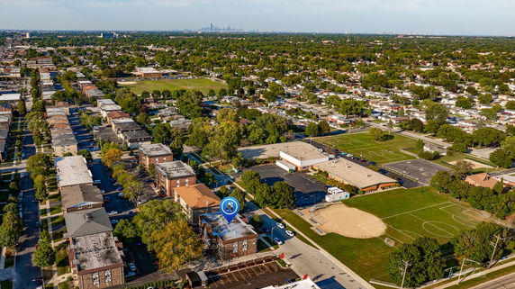 Wide-angle aerial view of a suburban neighborhood with residential buildings, streets, and greenery.